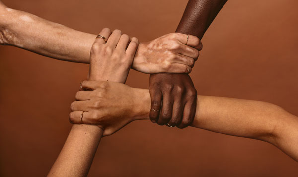Multi-ethnic hands holding each other in a circle