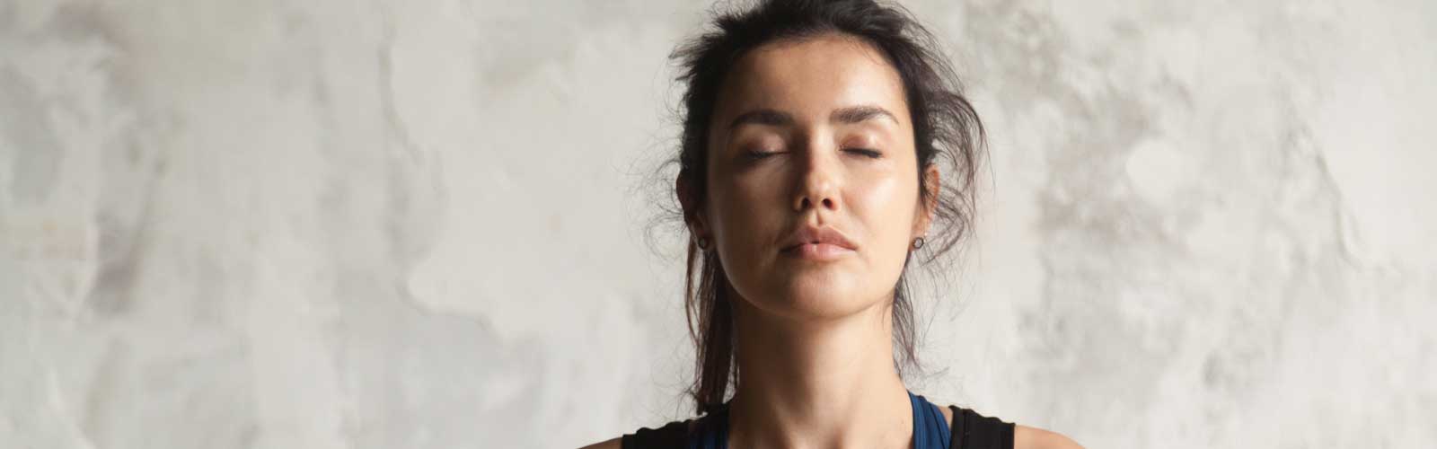woman's face with closed eyes practicing yoga stock photo