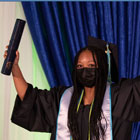 A Clovis Community College student in cap and gown, celebrates her graduation
