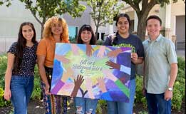 CCC Students holding a sign saying All are welcome here!