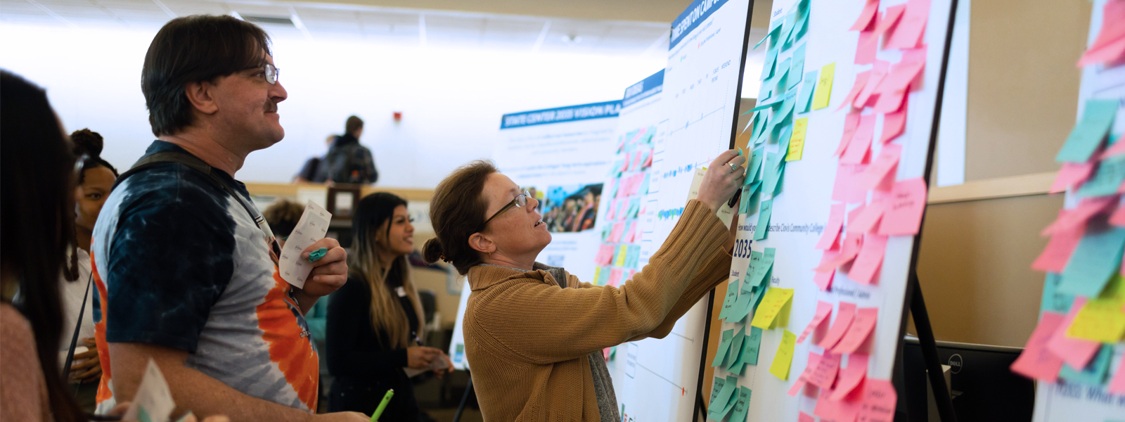 Clovis Community College employees post notes on a ideas board