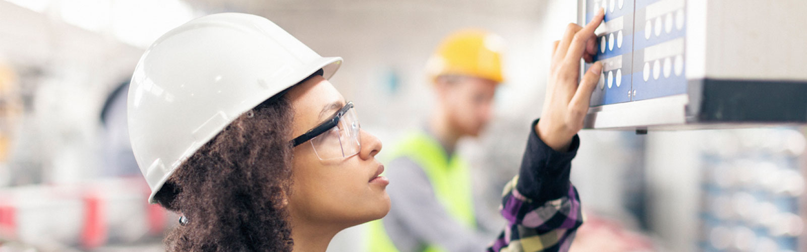 female worker at control table and electrician working with cable