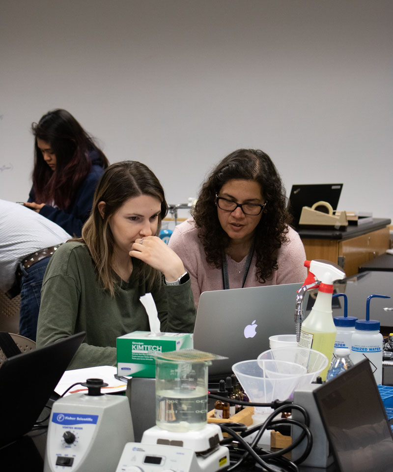 Instructor Rosa Alcazar with student in science classroom