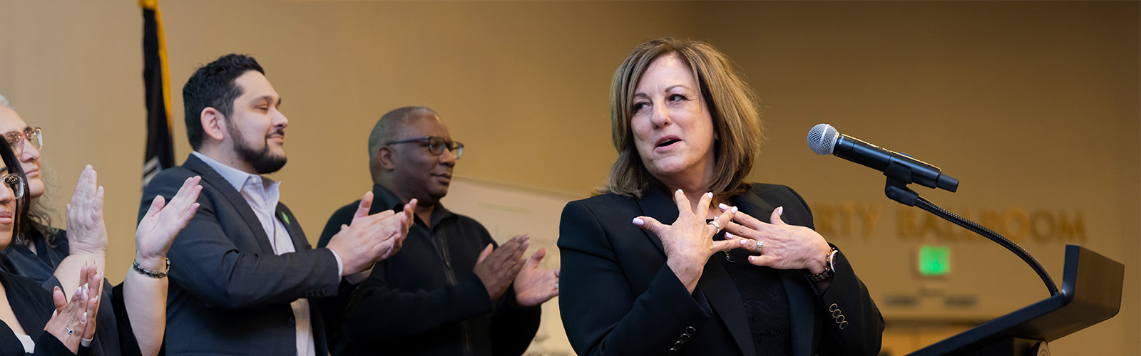 Woman speaking and people clapping
