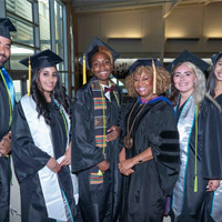 President Dr. Kim Armstrong poses for a photo with graduates