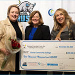 President Dr Bennet, Chancellor Dr. Goldsmith, and donor Jami Hamel De La Cerda pose with large check