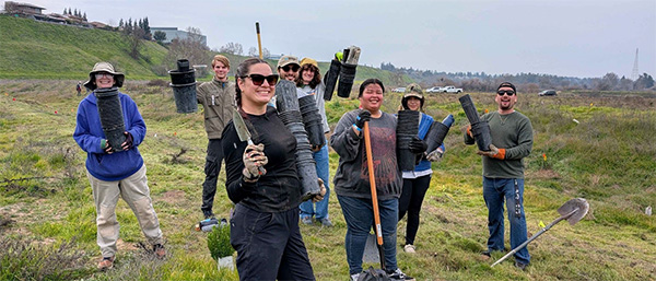 Conservation Club outdoors holding gardening tools