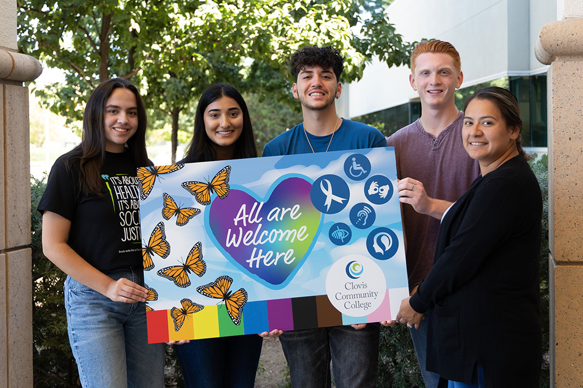 group of students holding an all are welcome here sign