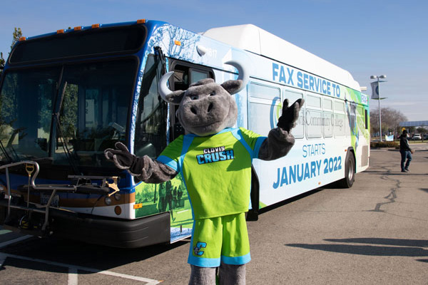 Crush mascot posing with FAX Bus