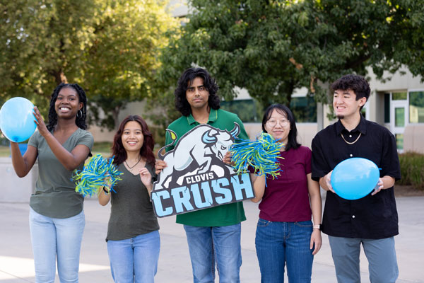 5 Students outside on campus smiling