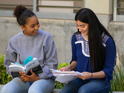 four students walking together, talking, and smiling