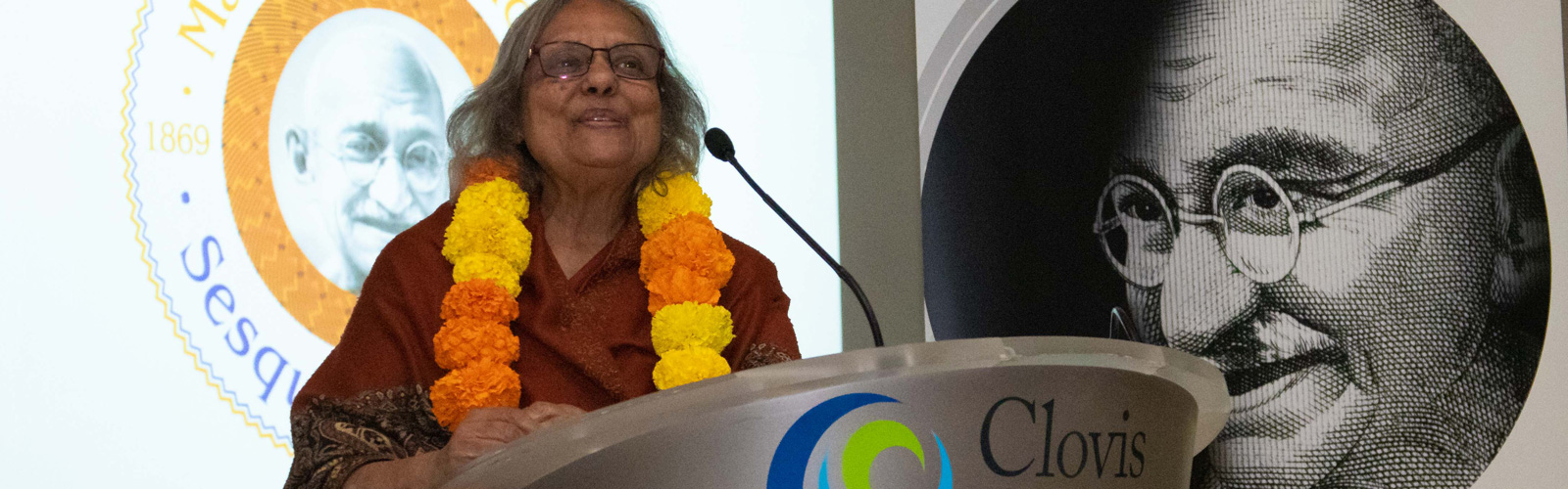 Ms. Ela Gandhi standing at the podium