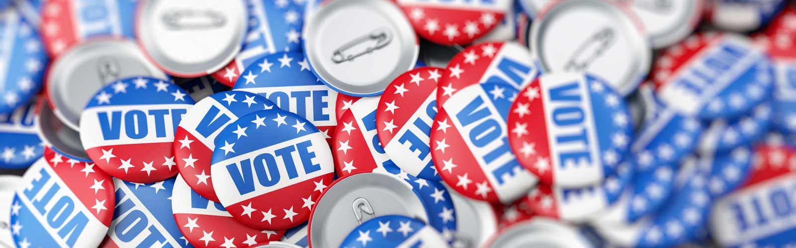 A tabletop of badges with the American flag and the word, "vote"