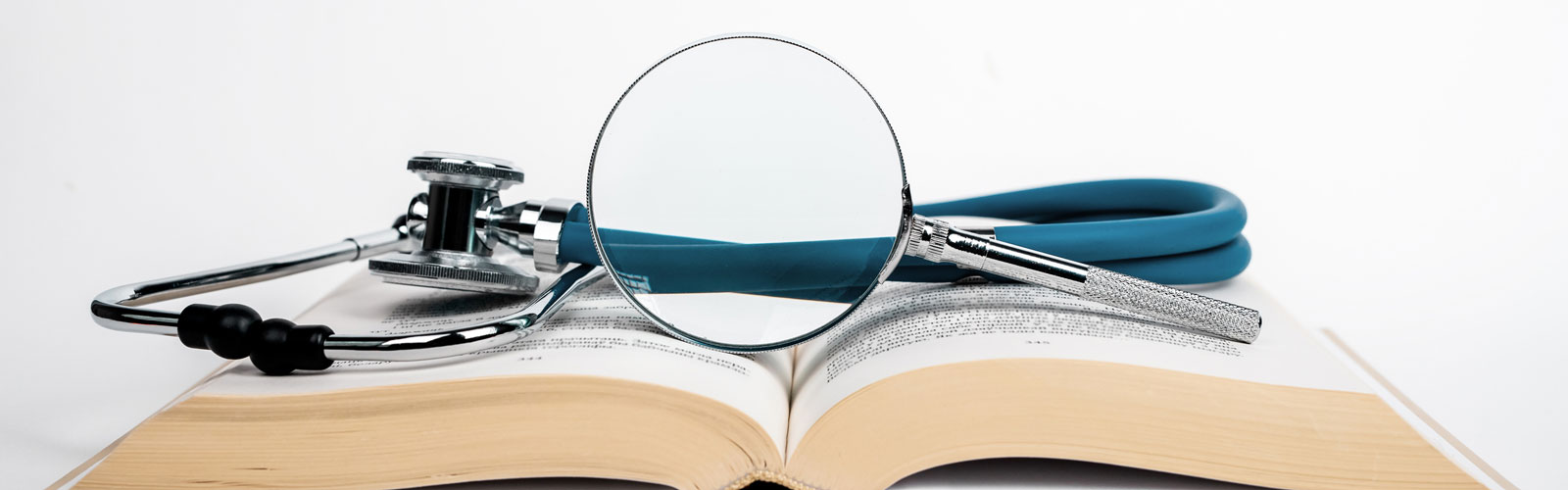 magnifying glass with stethoscope on book 