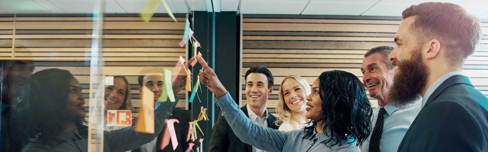 Colleagues discussing business on clear board