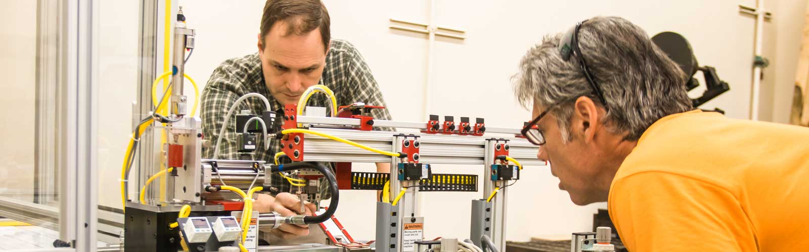 Mechatronics teacher, Mathew Graff, working with a student on a mechatronics project