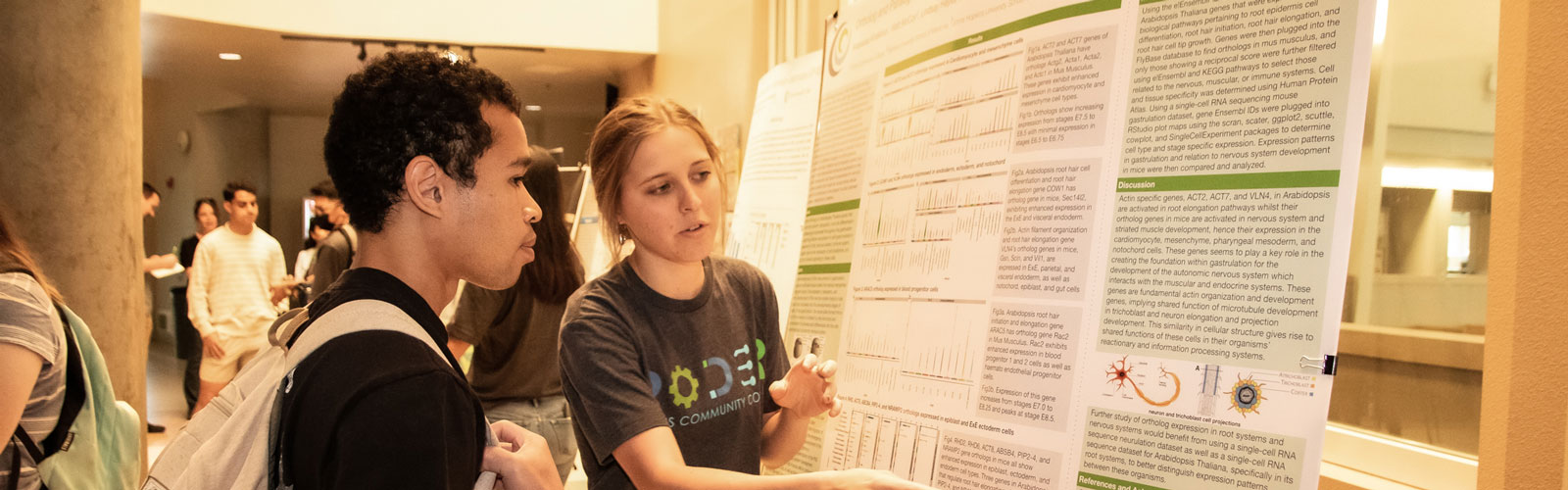 3 people gathered talking to each other, socializing, at the symposium