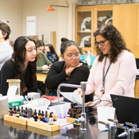 Dr. Rosa Alcazar, instructor, with students in science classroom