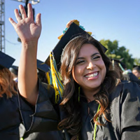 Female student waiving at the camera during commencement