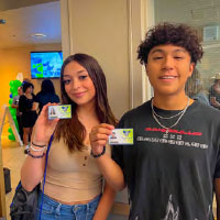 Students holding up student ID badge
