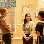 3 students standing, smiling, talking to each other