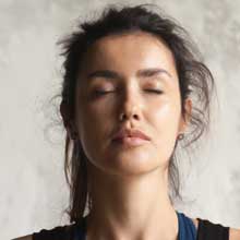 woman's face with closed eyes practicing yoga stock photo