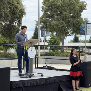 Speaker Isaac Reyna, Outreach Specialist, speaks to students from the stage. Sign language Interpreter standing offstage translates. 