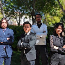 Speech and Debate Club members standing posing outside with arms folded