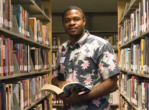 Library bookshelves with student in between