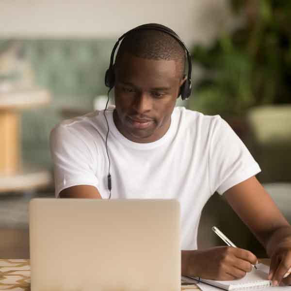 African American male student working on a laptop from home