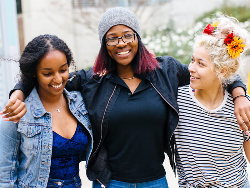 three female students hugging