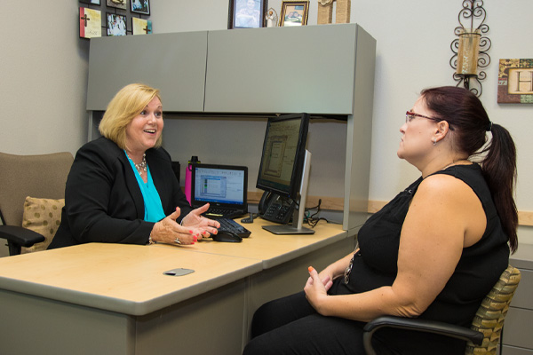 2 people having a discussion at a desk