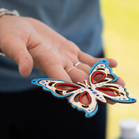 A woman's hand holding a decorative butterfly