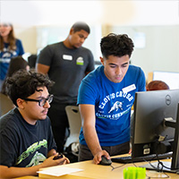An employee helping a student on the computer