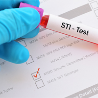 a blood vial that reads STI Test