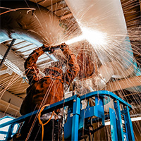 Man using an angle grinder on A.C. duct.