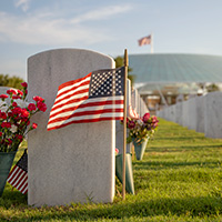 A graveyard with an American flag at one of the headstones