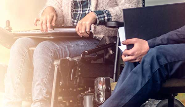 Student on wheelchair getting assistance by instructor