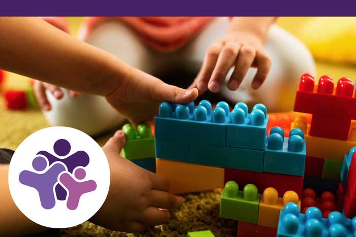 Close-up of two children playing with toy blocks.