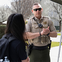 A police officer telling a female student about a career in law enforcement.