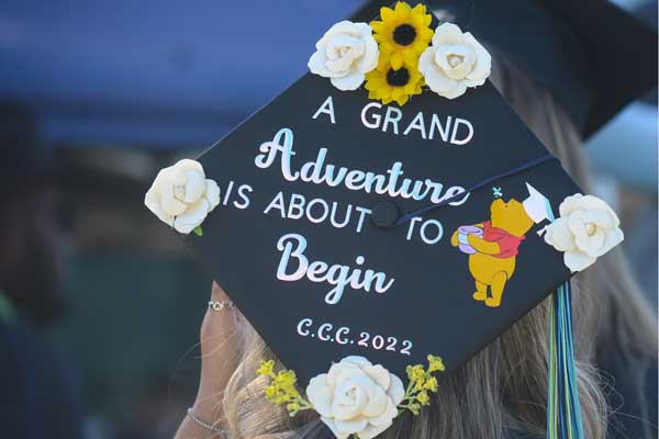 A graduation cap decorated with, "A grand adventure about to begin" and a picture of Winnie the Pooh