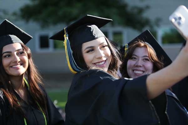 A group of female students in regalia taking a selfie
