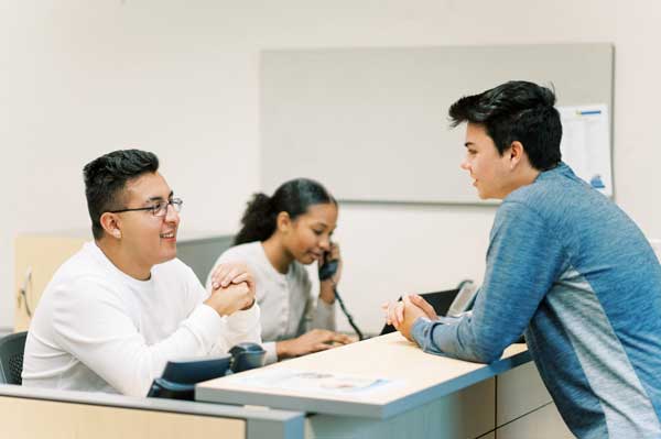 Students in the welcome center handling calls and enquiries