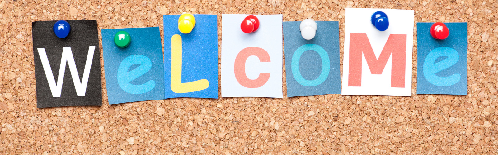 welcome spelled out on post it notes on a cork board