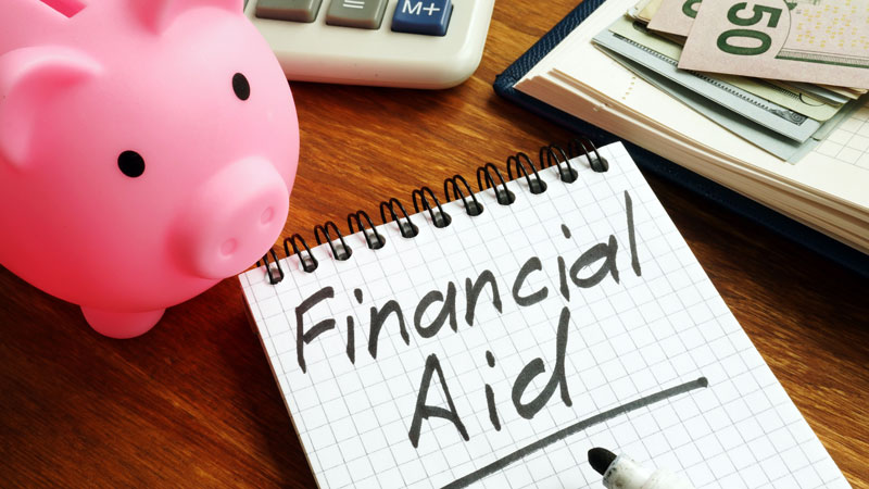 piggy bank with financial aid written on notepad