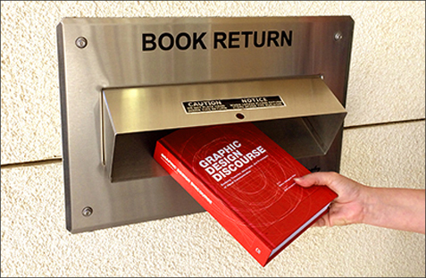 A red book being put into a box marked Book Returns