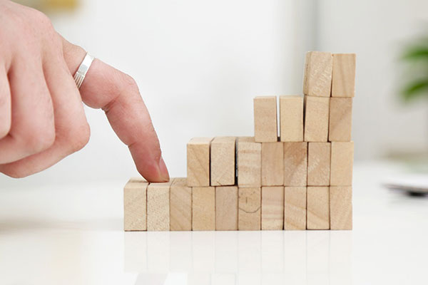 fingers walking up a stack of wooden blocks