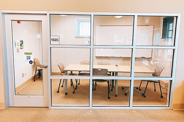 A room with a table, chairs, and a whiteboard