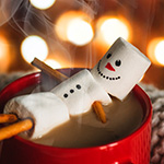 A snowman made of marshmallows relaxing in a cup of hot chocolate
