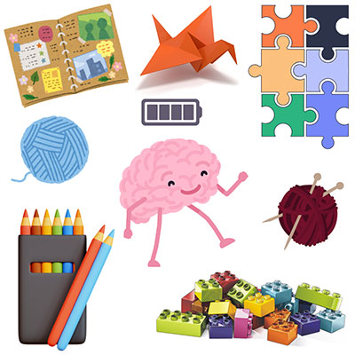 a smiling cartoon brain surrounded by balls of yarn, legos, origami, puzzle pieces, and coloring pencils